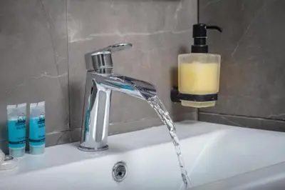 a bathroom sink with a water faucet and a candle at Jocasta - Cocoon Apartment Near Metro Station in Athens