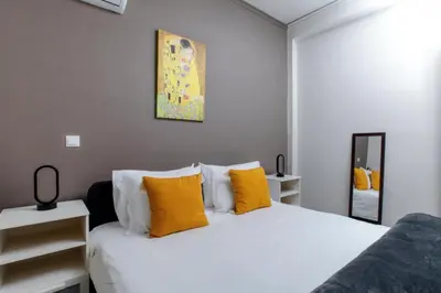 a bedroom with a white bed with yellow pillows at Jocasta - Cocoon Apartment Near Metro Station in Athens