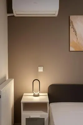 a room with a bed and a white night stand at Jocasta - Cocoon Apartment Near Metro Station in Athens