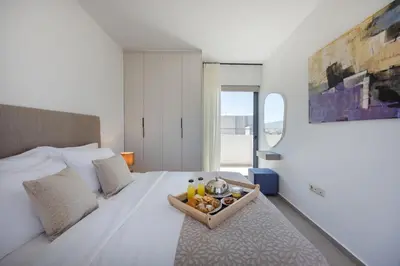 a bedroom with a bed with a tray of food on it at Sokio Attiki Hotel, BW Premier Collection in Athens