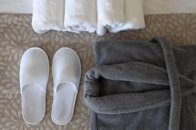 a pair of shoes and a towel on a bed at Sokio Attiki Hotel, BW Premier Collection in Athens