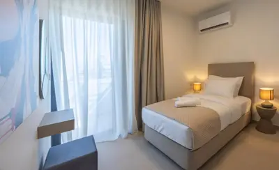 a bedroom with a bed and a large window at Sokio Attiki Hotel, BW Premier Collection in Athens
