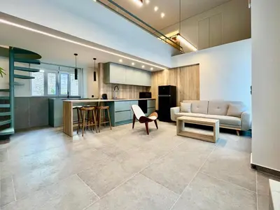 a kitchen and living room with a couch and a table at Loft in Pagkrati in Athens