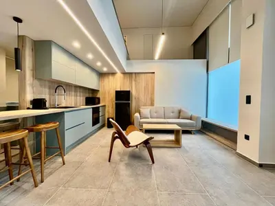 a kitchen and living room with a couch and a table at Loft in Pagkrati in Athens