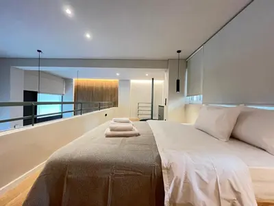 a bedroom with a large bed with two towels on it at Loft in Pagkrati in Athens