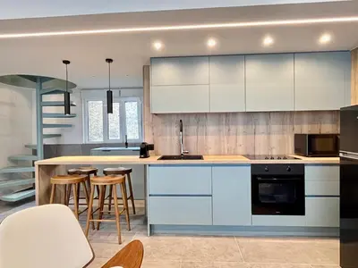 a kitchen with white cabinets and bar stools at Loft in Pagkrati in Athens