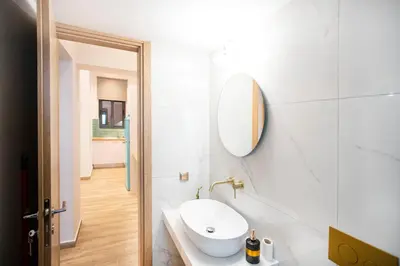 a white bathroom with a sink and a mirror at The New Flat 183 - Ground floor, fully renovated in Athens