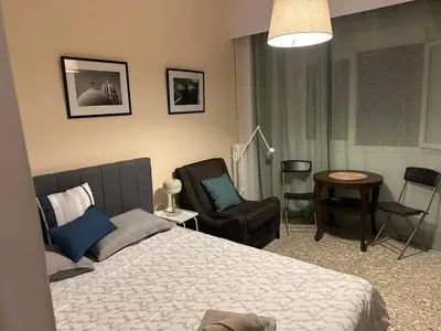 a bedroom with a bed and a chair and a table at Central Modern Stay Apartment-5min walk from metro in Athens
