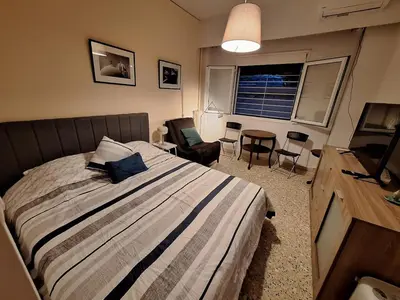 a bedroom with a bed and a table and chairs at Central Modern Stay Apartment-5min walk from metro in Athens