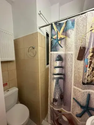 a bathroom with a shower curtain with a toilet at Central Modern Stay Apartment-5min walk from metro in Athens