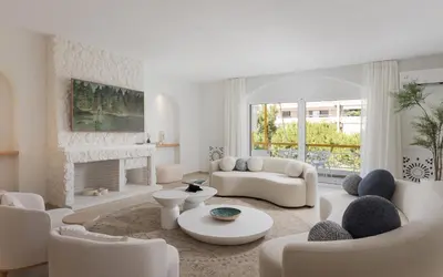 a living room with white furniture and a fireplace at Arche Residence Glyfada in Athens