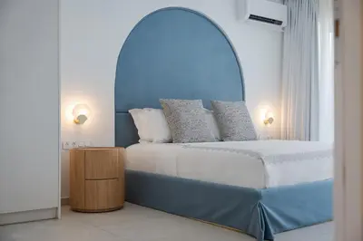 a bedroom with a large bed with a blue headboard at Arche Residence Glyfada in Athens