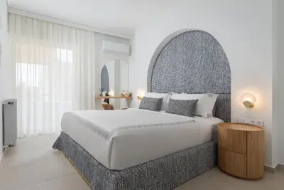 a bedroom with a large bed and a large window at Arche Residence Glyfada in Athens