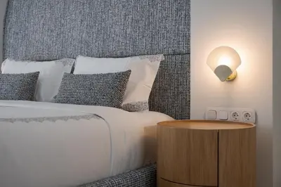 a bedroom with a bed with a wooden table next to it at Arche Residence Glyfada in Athens