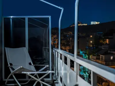 a chair sitting on a balcony at night at Town house by Phoenix Apartments in Athens