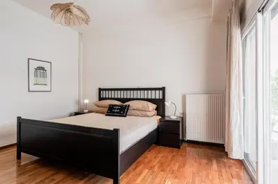 a bedroom with a bed and a large window at Town house by Phoenix Apartments in Athens