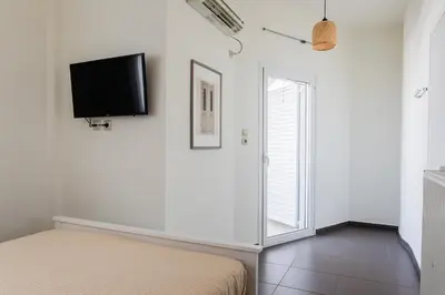 a bedroom with a bed and a flat screen tv on the wall at Town house by Phoenix Apartments in Athens