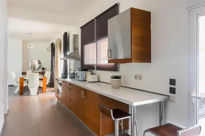 a kitchen with wooden cabinets and a counter top at Town house by Phoenix Apartments in Athens