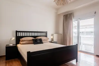 a bedroom with a large bed and a large window at Town house by Phoenix Apartments in Athens