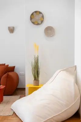 a living room with a couch and a pillow on the floor at RoomsByRamez -Chill Bright Stay- -Central Athens- in Athens