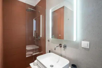 a bathroom with a toilet and a sink and a mirror at RoomsByRamez -Chill Bright Stay- -Central Athens- in Athens