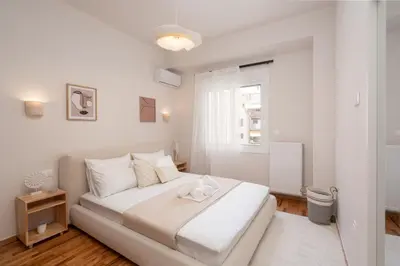 a white bedroom with a bed and a window at RoomsByRamez -Chill Bright Stay- -Central Athens- in Athens