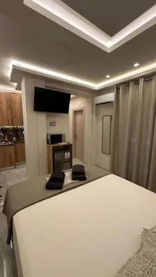 a bedroom with a bed and a flat screen tv at Lush Studio Apartment in Athens