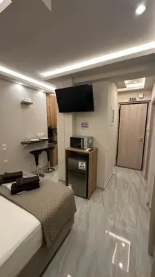 a bedroom with a bed and a flat screen tv at Lush Studio Apartment in Athens