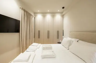 a white bedroom with two beds with white pillows at Rooms151 Premium Suite in the Heart of Athens 4th floor-9 in Athens