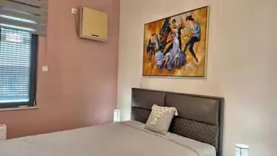 a bedroom with a bed and a painting on the wall at Solonos Amber Muse in Athens