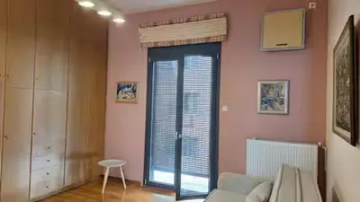 a living room with a couch and a large window at Solonos Amber Muse in Athens