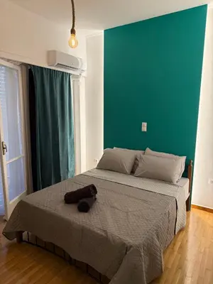 a bed in a bedroom with a green wall at The Athenian Chic in Athens