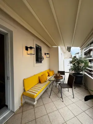 a living room with a yellow couch and a table at Central Athens Unique Apartment in Athens