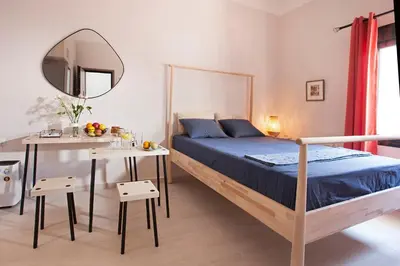 a bedroom with a bed and a table with a mirror at Cozy Apartment Next To PIRAEUS PORT in Piraeus