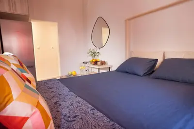 a bedroom with a blue bed and a mirror at Cozy Apartment Next To PIRAEUS PORT in Piraeus