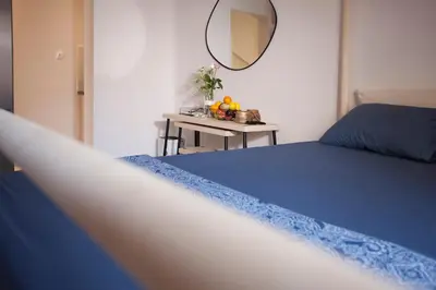 a bedroom with a bed and a table with a mirror at Cozy Apartment Next To PIRAEUS PORT in Piraeus