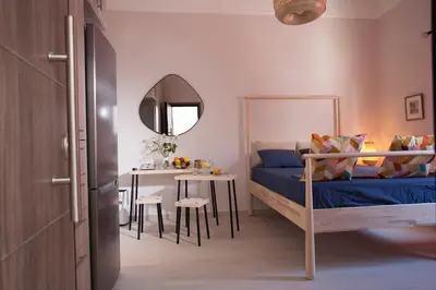 a bedroom with a bed and a table and a mirror at Cozy Apartment Next To PIRAEUS PORT in Piraeus