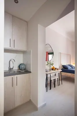 a kitchen with a sink and a table in a room at Cozy Apartment Next To PIRAEUS PORT in Piraeus