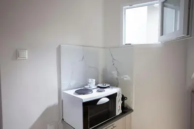a small kitchen with a microwave and a window at Cozy Apartment Next To PIRAEUS PORT in Piraeus