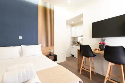 a bedroom with a bed and a desk with two chairs at Modern Rooms Pagrati in Athens