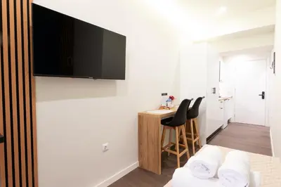 a bedroom with a bed and a desk with chairs at Modern Rooms Pagrati in Athens