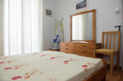 a bedroom with a bed and a mirror and a chair at Minimal Flat in Historic Kerameikos by ΜΡS in Athens