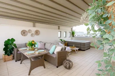 a patio with a couch and table and a tub at Sky Suite with View & Jacuzzi in Athens