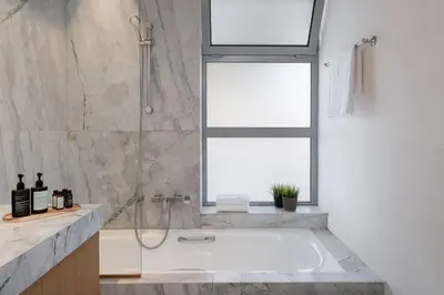 a bathroom with a bath tub and a window at 3BD 2 Floor Maisonette with Pool in Athens