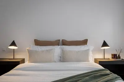 a bedroom with a large white bed with two lamps at 3BD 2 Floor Maisonette with Pool in Athens