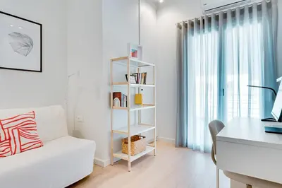 a living room with a white couch and a book shelf at Kerameikos Acropolis view in Athens