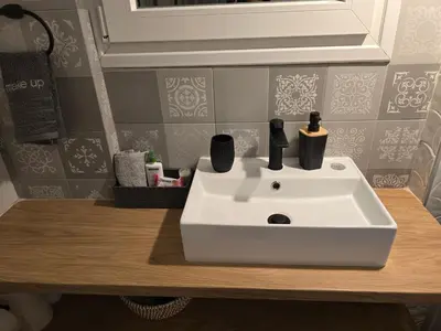 a bathroom sink with two cups on top of it at Down town in Athens