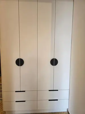 a white wardrobe with three black knobs on it at Down town in Athens