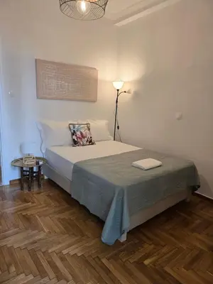 a bedroom with a bed with a lamp and a table at Down town in Athens