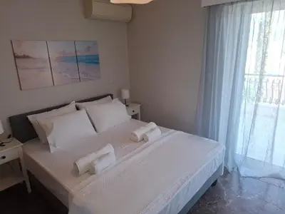 a bedroom with a white bed with two towels on it at Bright & comfortable apartment for a pleasant stay! in Vari